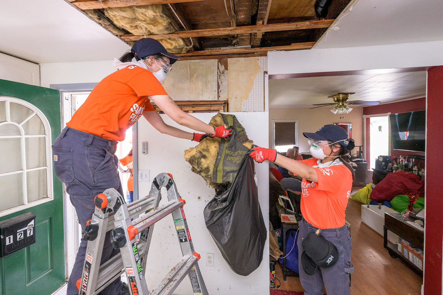 Samaritan's Purse volunteers remove soiled insulation from Jason's ceiling, damaged by the nine inches of rain they received.